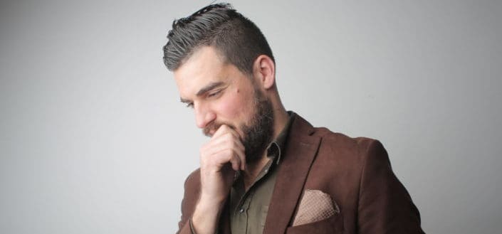 ¿Cómo Elegir Los Mejores piropos lindos? - Pensive man in brown coat holding his chin