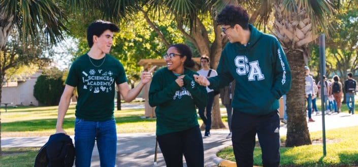 un grupo de estudiantes universitarios riendo mientras camina