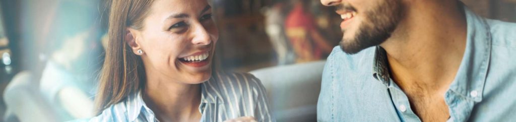 Young attractive cheerful couple on date in coffee shop