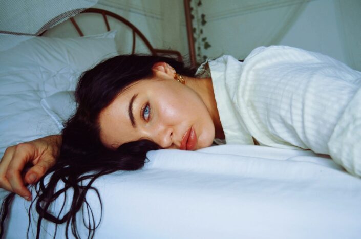 Hermosa mujer de ojos azules acostada en su cama