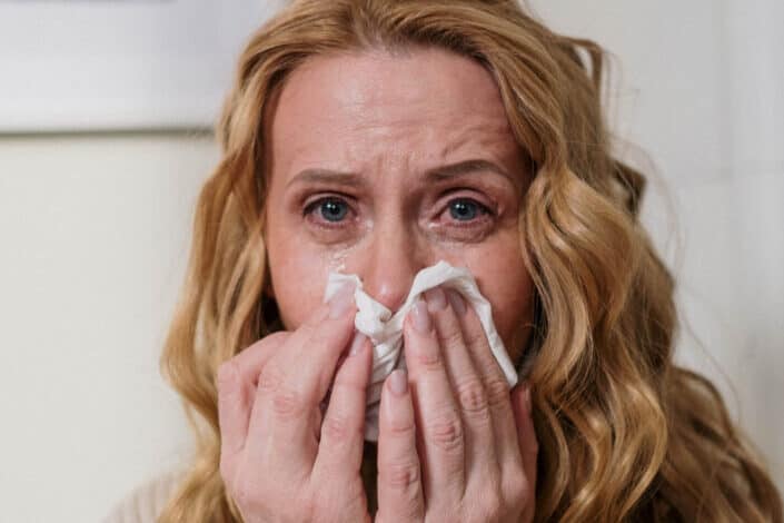 mujer rubia llorando con pañuelo