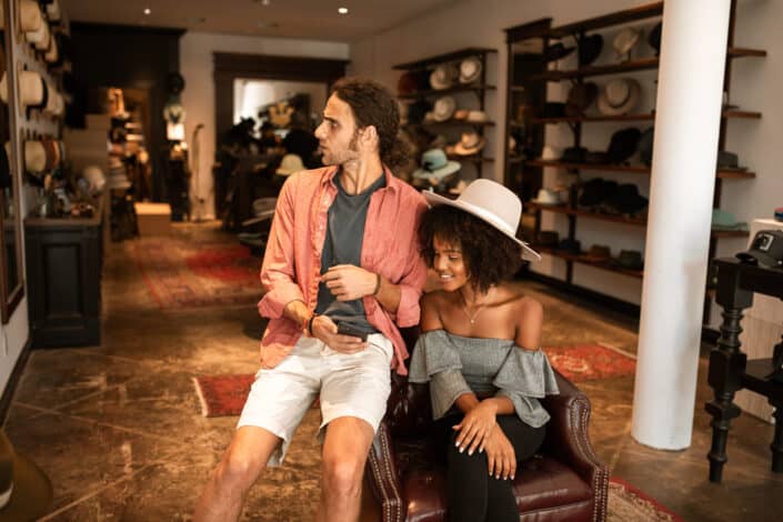 hombre y mujer sentados en una tienda de sombreros