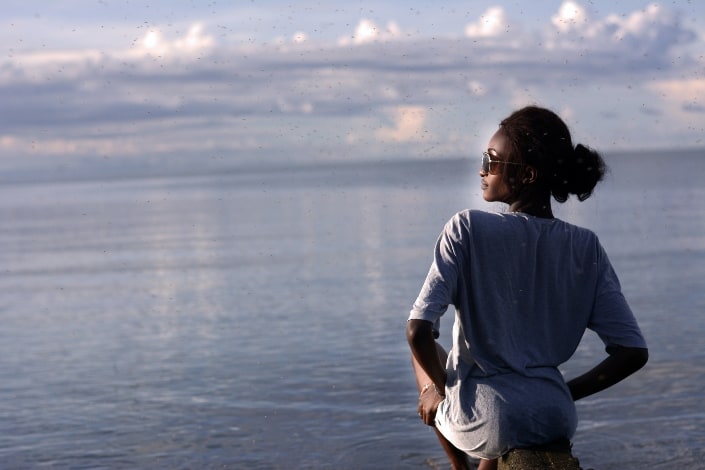 Mujer sentada junto al mar