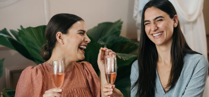 Dos mujeres divirtiéndose mientras bebe un vino rosado