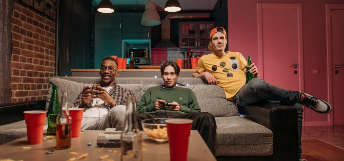 Hombres sentados en el sofá mientras juegan videojuegos