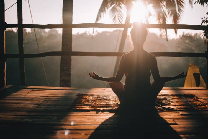 mujer haciendo yoga mirando la jungla de Bali