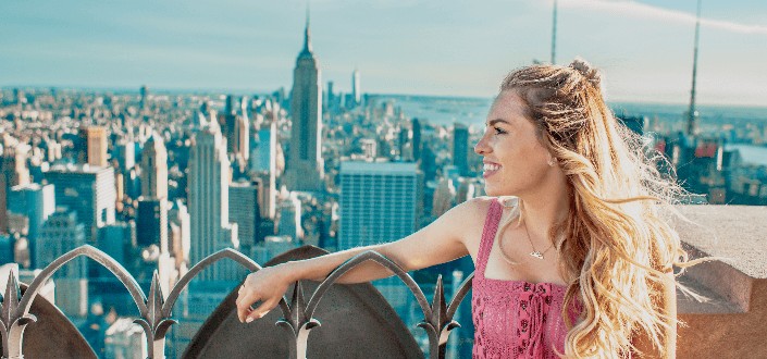 woman on top of a tower looking at the Empire State Building