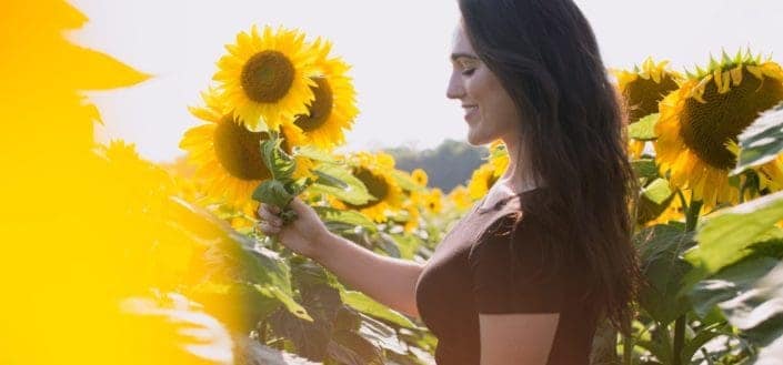 woman standing among sunflowers