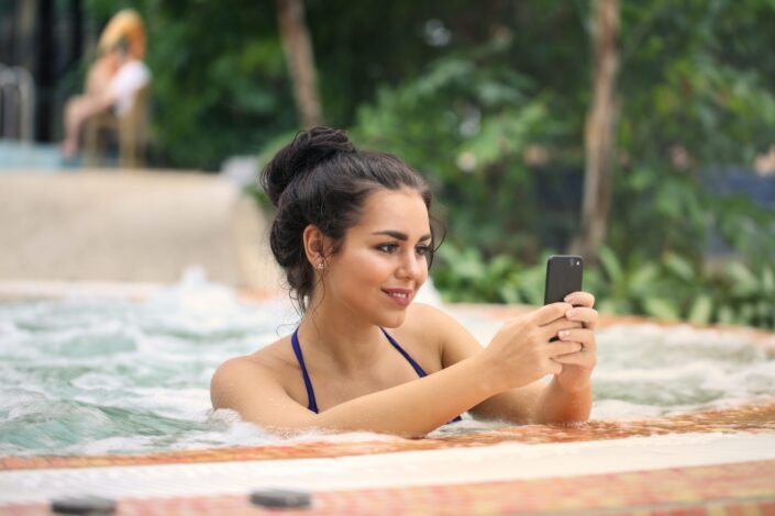 photo-of-a-woman-in-jacuzzi-using-smartphone-