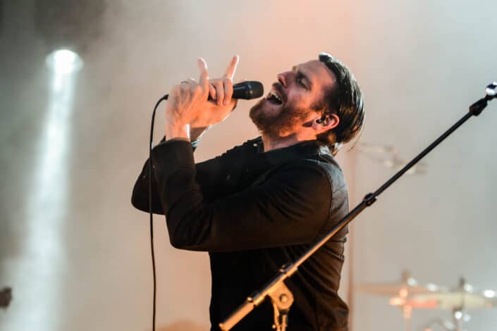 Hombre vestido con camisa de manga larga con cuello negro con micrófono