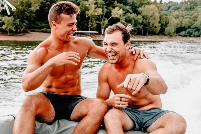 dos hombres sentados en un bote mientras se ríen